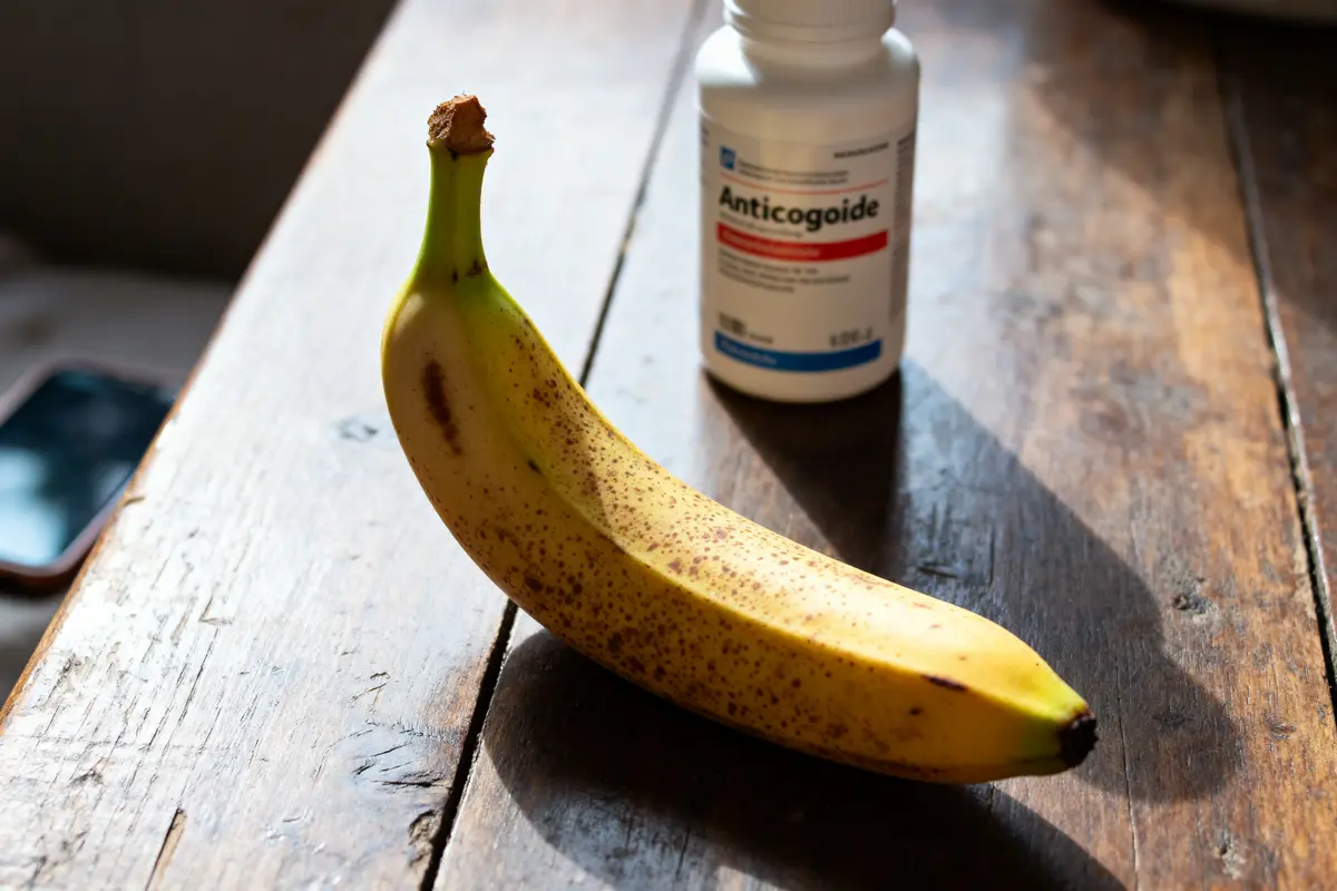 Banane mûre sur table en bois avec flacon d'anticoagulant en arrière-plan