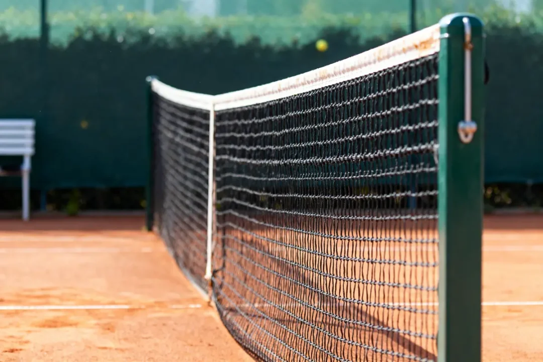 Filet de tennis sur terre battue illustrant la hauteur du filet de tennis standard