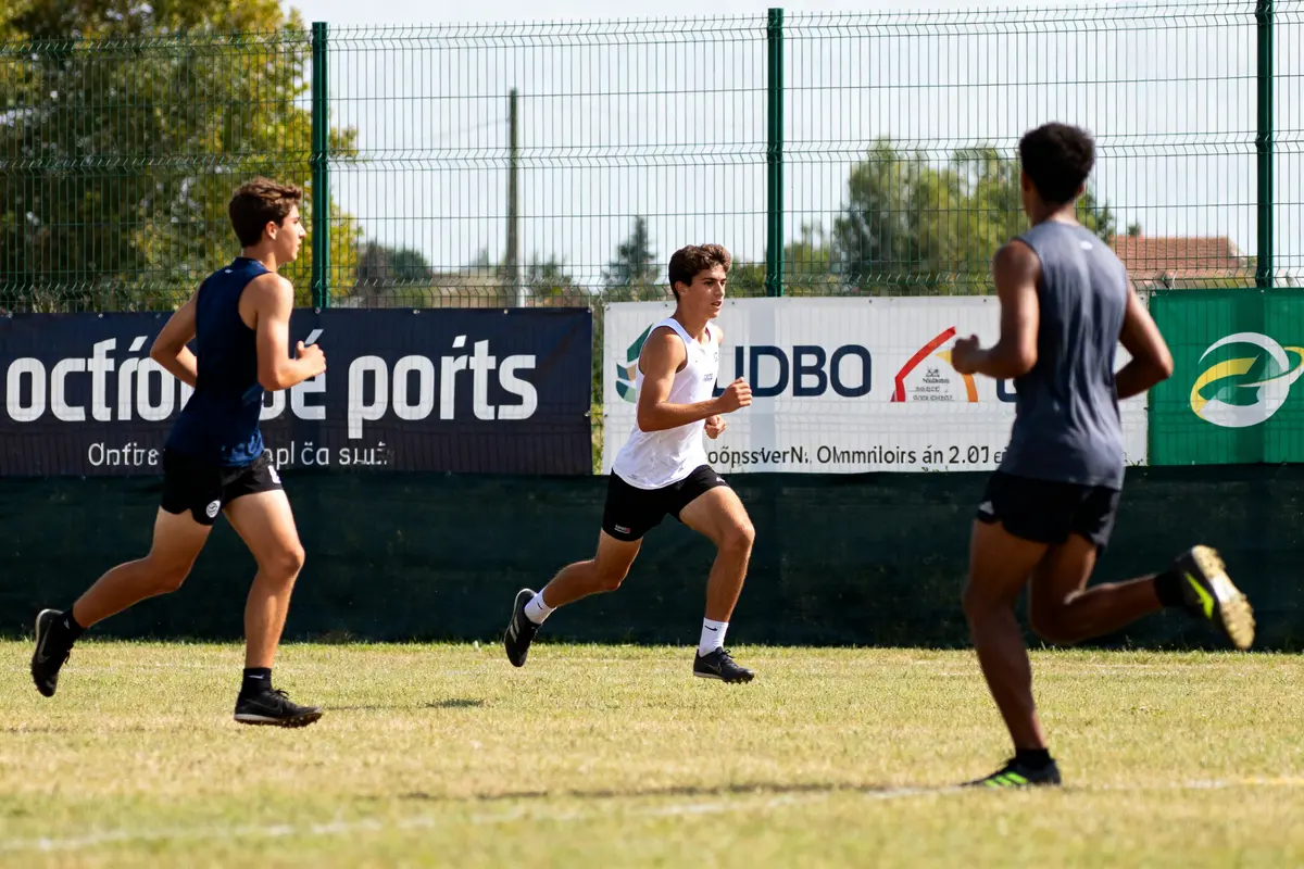Trois jeunes hommes courant sur un terrain en entraînement sport en O extérieur