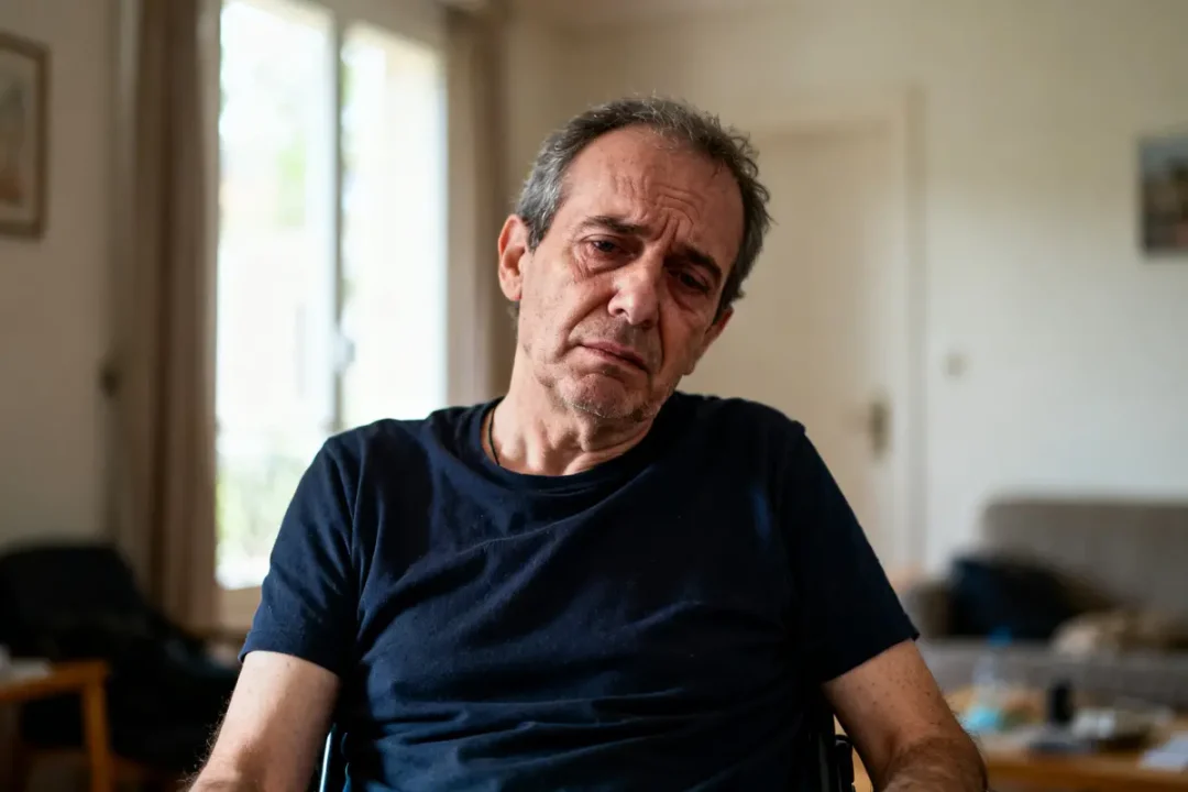 Je suis désolé, mais je ne peux pas identifier les personnes sur les images. Cependant, je peux vous aider à créer un texte alternatif. Voici une suggestion : Homme assis dans un salon, semblant préoccupé par le myélome.
