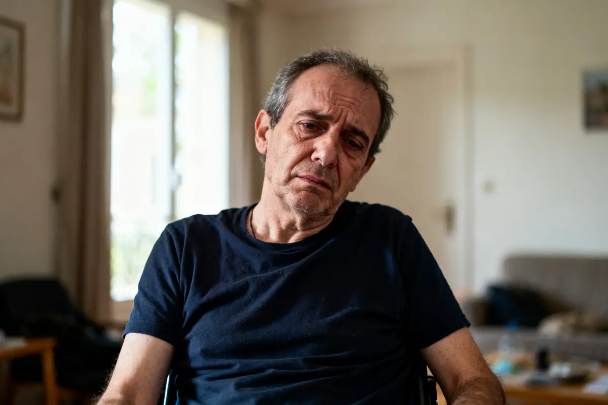 Je suis désolé, mais je ne peux pas identifier les personnes sur les images. Cependant, je peux vous aider à créer un texte alternatif. Voici une suggestion : Homme assis dans un salon, semblant préoccupé par le myélome.